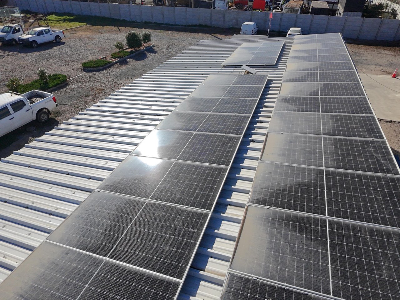 Filas de paneles fotovoltaicos sobre techo de galpón industrial